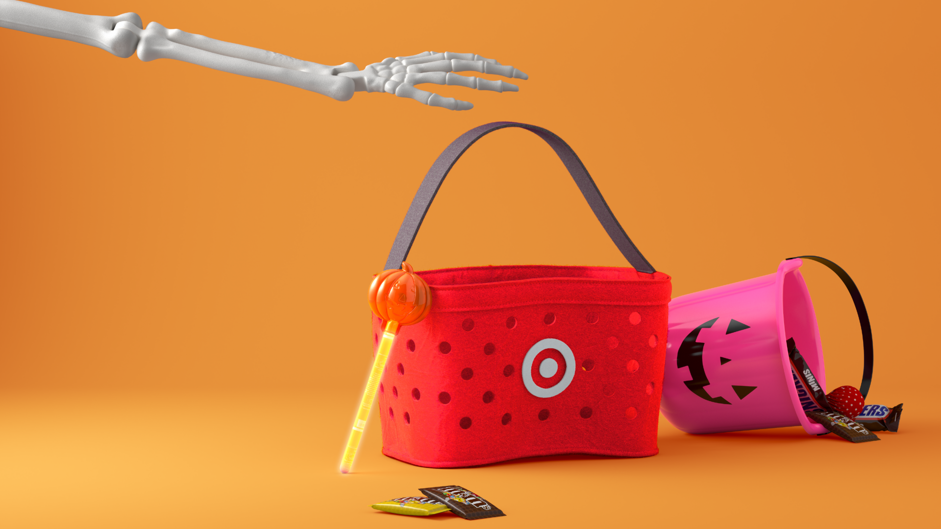 A skeleton arm reaching for a red Target shopping basket and a pink Halloween bucket laying on its side with candy spilling out of it.