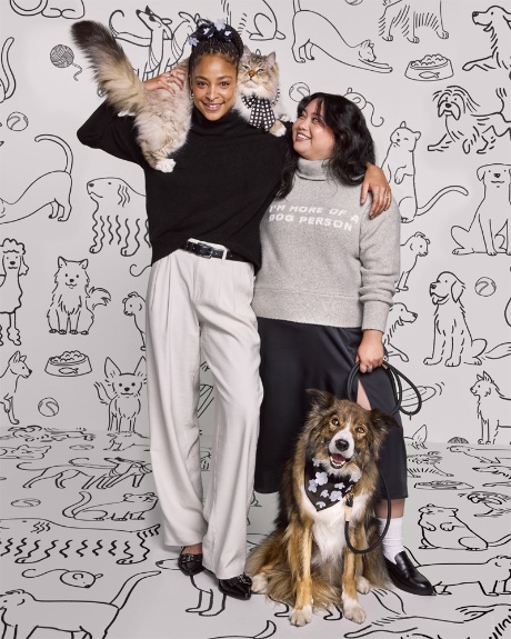 Two models pose with a cat and dog wearing The Cuddle Collab collection.