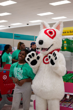 A Little smiles next to Bullseye, the Target mascot, during a back-to-school shopping event at Target.