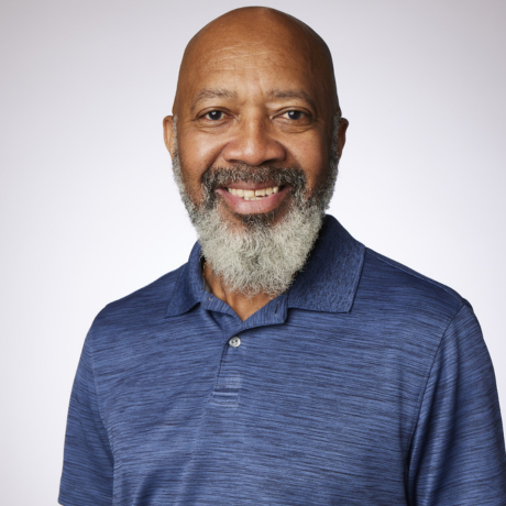 Julius smiles at the camera while wearing a dark blue shirt.