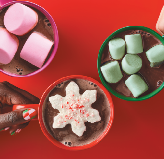 Three mugs of hot cocoa with colorful marshmallows.