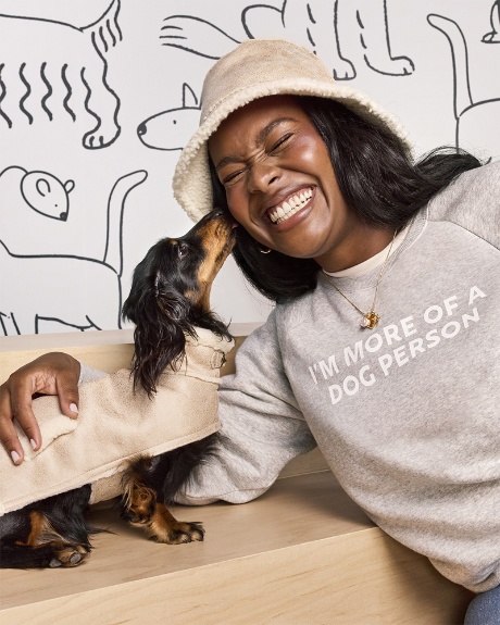 A model and dog pose wearing The Cuddle Collab collection.