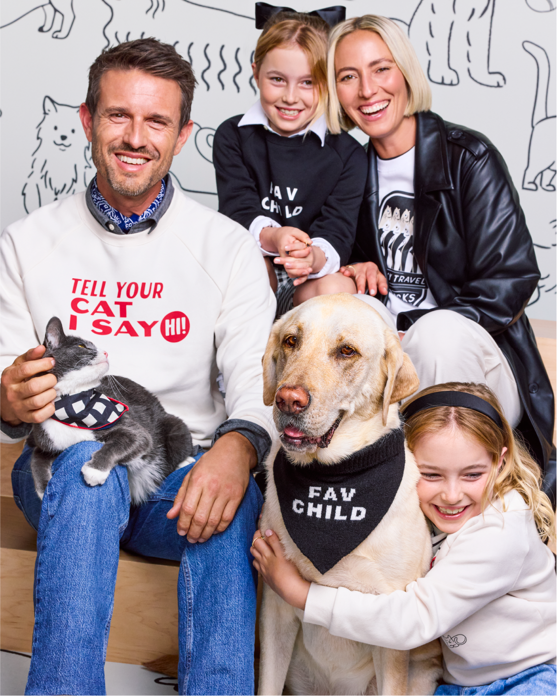 A family poses with a cat and dog, all wearing items from The Cuddle Collab.