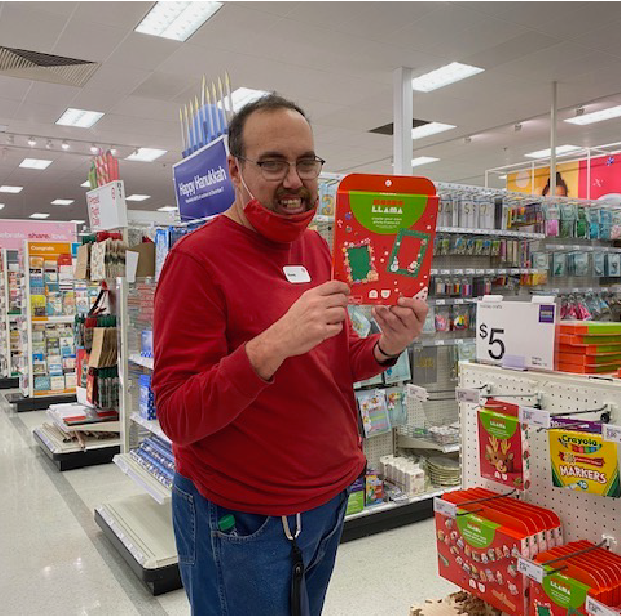 Team Member Randy G. holds a gift and smiles.